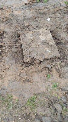 Headstone has been dug up and muddy