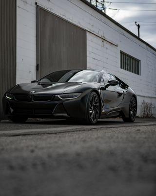 BMW i8 - Wrapped with an Aggressive Satin Black by Avery Custom Red Caliper Job Sleek Headlight Tint Lamination 5% Tint All around