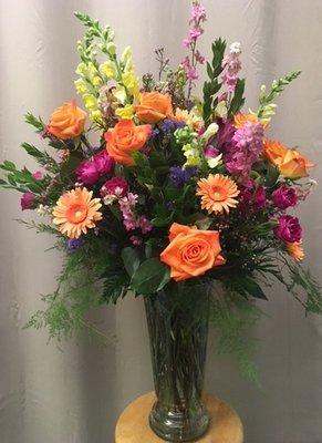 A colorful summer vase showcasing orange roses