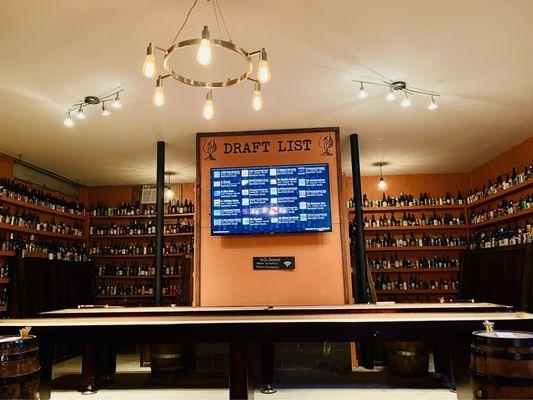 Tabletop shuffle board tables and indoor seating nooks surrounded by rare bottles.