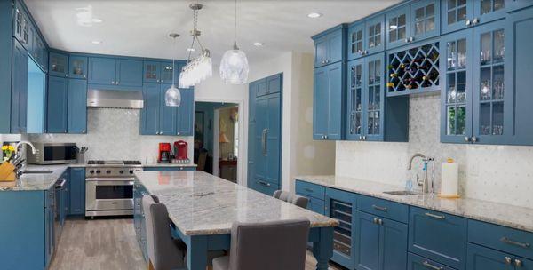 Blue shaker style cabinets with a white tile backsplash, wine cabinets, and glass doors