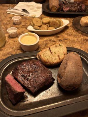 10 oz flat iron medium rare with baked sweet potato. Fried pickles in the background.