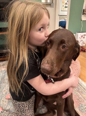 Our daughter loving on the chocolate lab they helped find and take care of.