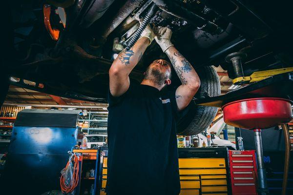 An auto technician hard at work on a repair.