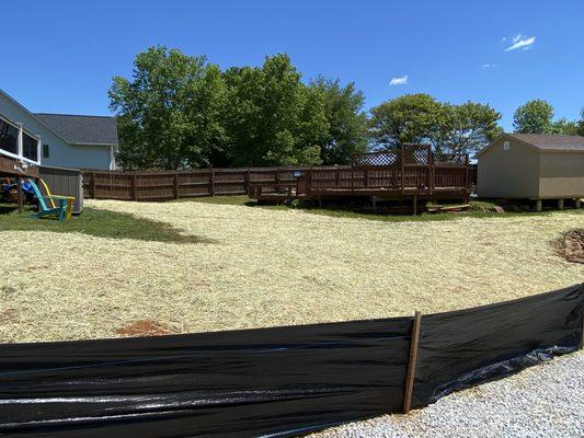 Drain pipe covered with dirt, grass seed, and straw instead of a ditch!