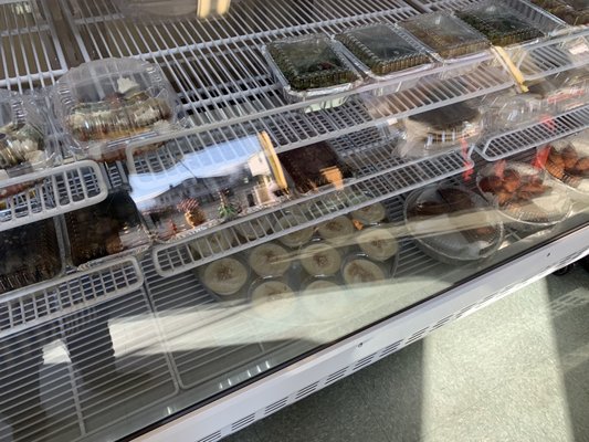 Prepared food items on a glass enclosed refrigerated display shelves.