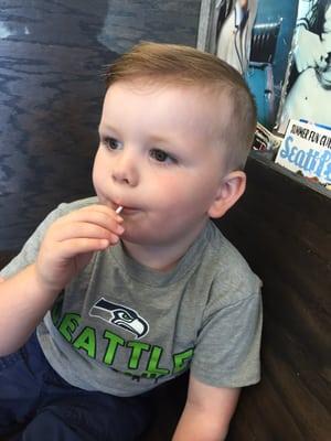 One happy little man with a sucker and fresh new haircut!