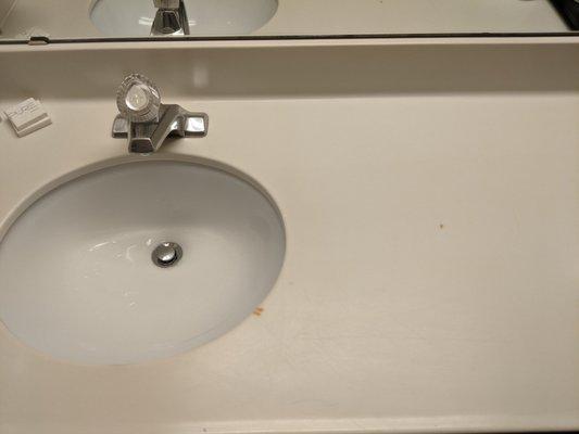 Cigarette burns on sink area in non-smoking room.