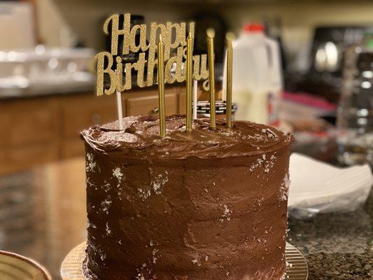 Three-tier chocolate sea salt cake and happy birthday pick