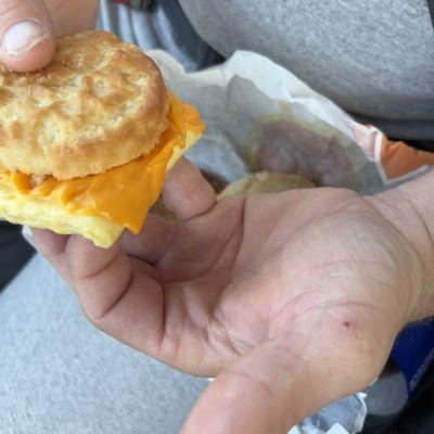 A hard biscuit over cooked egg with cheese that was just melted in microwave