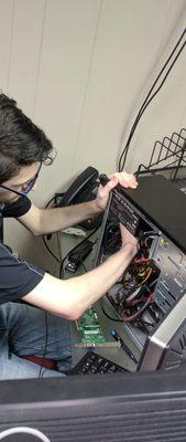 Drake Peper fixing a computer tower.