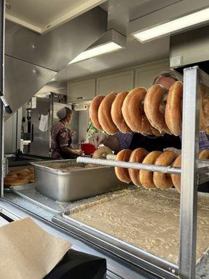 Dripping glazed donuts ready to be boxed up and delight your tastebuds.