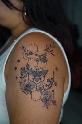 Bee and geometric honeycombs with fine line floral accents. Tattoo done by Eric @_tattoobymonotone_