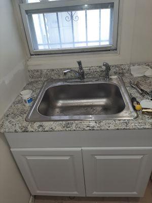 Newly installed kitchen cabinet, countertop and sink with faucet