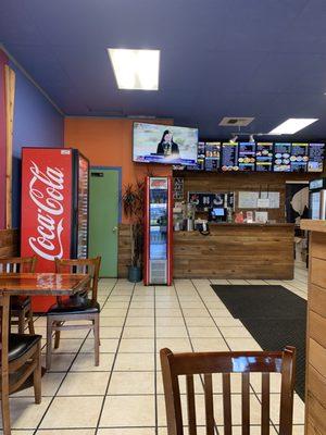 Counter area, menu board and drink coolers from back corner of dining area