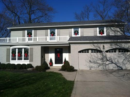 We painted the brick and siding the gray body color, painted trim and railing white, painted and hung custom built shutters.