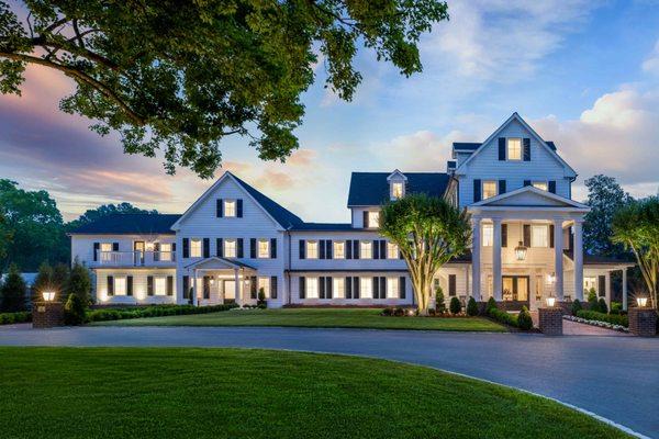 Exterior view of the front entrance of The Oaks Waterfront Hotel at dusk