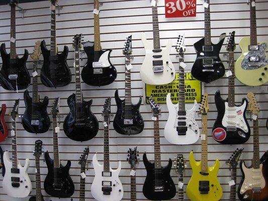 A wide selection of guitars available for sale.