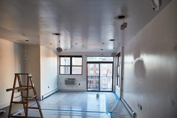 Water damage restoration: here the team is finalizing the light installation upon all new sheetrock installation.