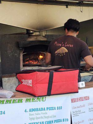 Pizza chef tending the wood-fired oven