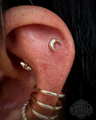 Yellow gold and CZ, "Moonshine" end in a fresh flat piercing. 
Performed by Parker with jewelry from Buddha Jewelry!