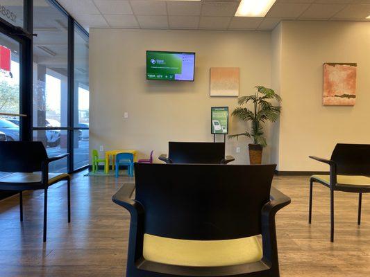 Waiting room with TV playing shows and intermittently displays your abbreviated name (for patient privacy) and approximate wait times.