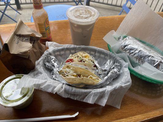 Two tacos, chips and guacamole, a burrito, horchata.