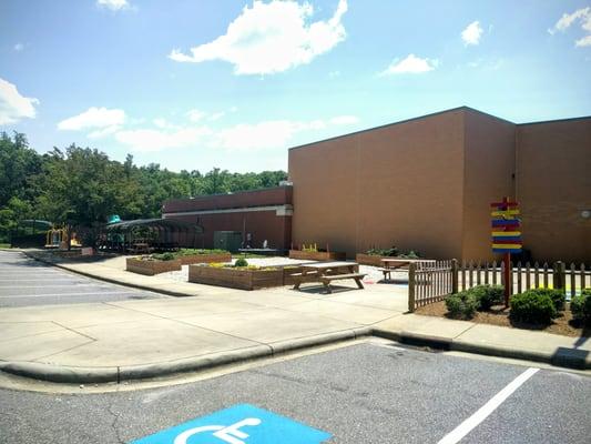 Side of the building includes small community garden, sidewalk games and playground, great for the kids camps they offer.