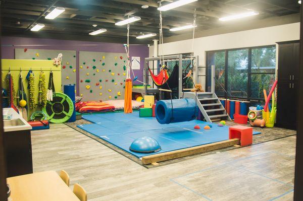 This is our large sensory gym with rock climbing wall, monkey bars, zip line and ball pit! We also have indoor swing hooks!