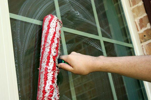 Scrubbing a window involves using soap and water with a scrub bar to remove dirt, grime, and other debris from the surface of the window.