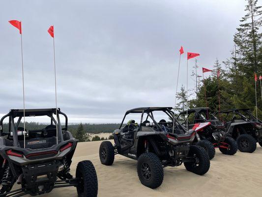 3- 2 seat RZR Turbo S and a single seat RZR RS-1 overlooking the sand dunes and ocean.