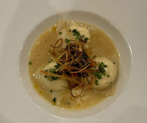 Ravioli filled with crab served with caviar, leeks and tomato