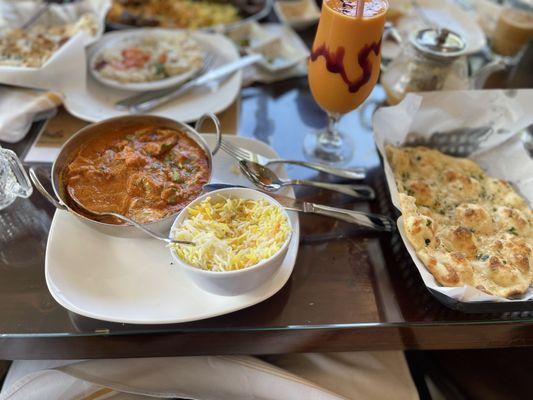 Butter chicken and garlic naan with mango lassi as the drink