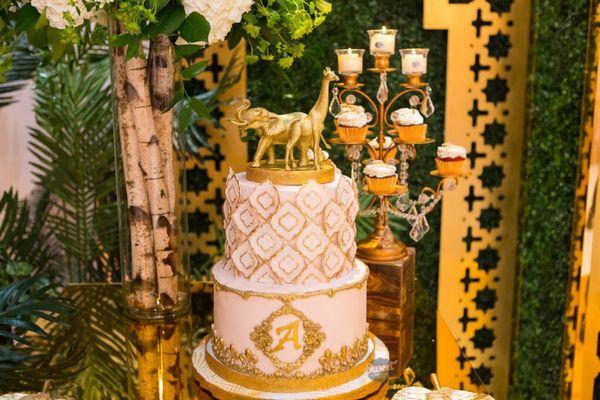 Royal glam safari baby shower cake with a gold elephant and giraffe topper