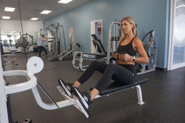 Personal trainer at FitMe Wellness demonstrating proper strength training techniques in our weight room area at FitMe Wellness in Rockford.