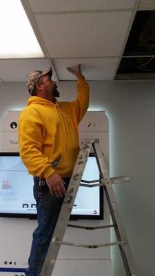 An employee Eric Pattison changing out ceiling tiles in an NTB on National Rd. Wheeling, Wv.