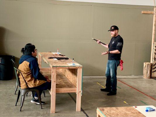 The instructor/owner giving a quick lesson before a couple starts throwing.