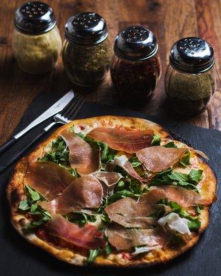 Al Prosciutto Pizza: Homemade pizza dough. Tomato sauce, mozzarella, prosciutto and arugula