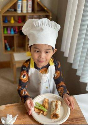 Our little Chef showing off food prepared during the online cooking class.