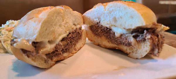 Prime Rib Sandwich (fried onions, cheese, au jus, on a hard roll) with a side of slaw.