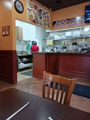 Kitchen to the right behind the shelves.