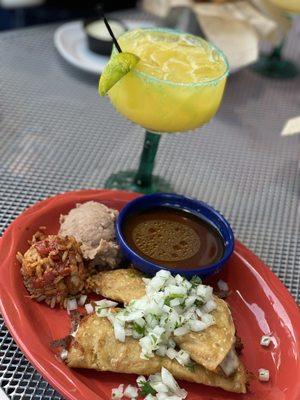 Outside sitting area. Quesabirria Tacos with side of rice and beans. With a delicious mango margarita.