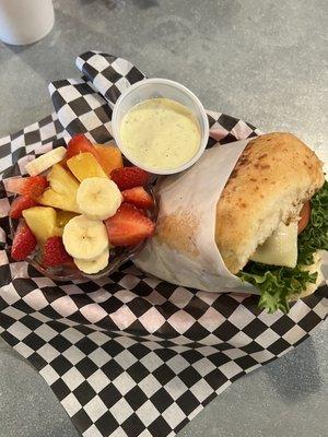 Grilled Chicken sandwich on a jalapeno bun with a side if fruit