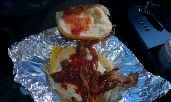 Bacon egg and cheese on hard roll with ketchup