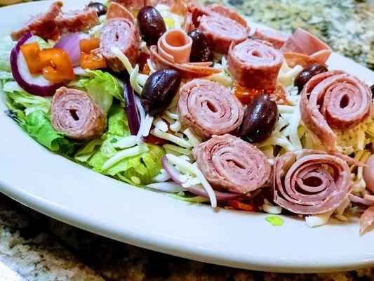 Antipasto Salad Colorful blend of mixed greens, topped with tomato, red onion, salami, ham, Kalamata olives and mozzarella cheese.