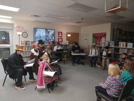 A Christmas Carol reading in period-ish attire.