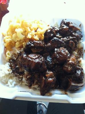 Oxtail with white rice and a side dish of macaroni and cheese