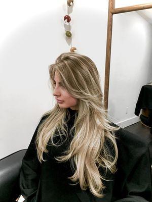 Beach blonde balayage and long layered haircut with feathered curtain bangs. Stylist, Sovay