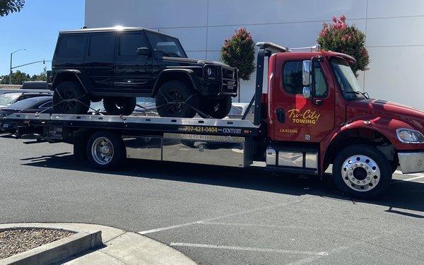 Flatbed towing a high end 4 wheel drive.