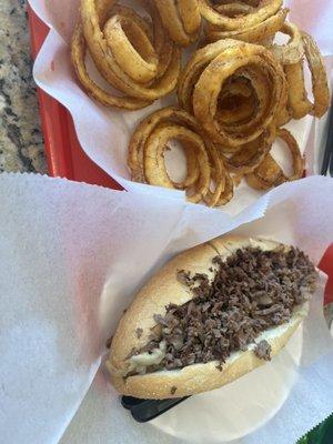 Steak and cheese sandwich with onion rings